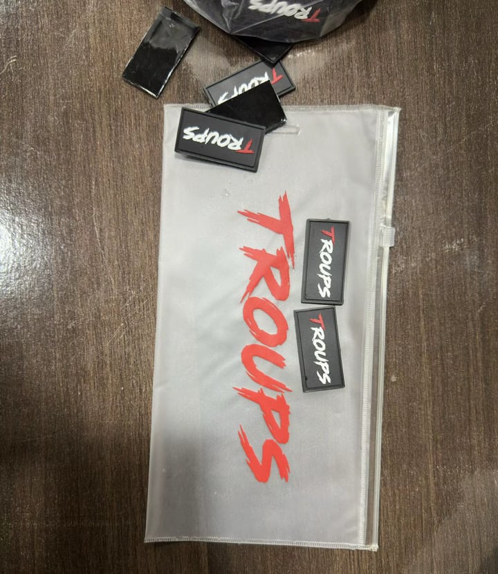 Etiquetas de goma Troups junto a la bolsa del packaging