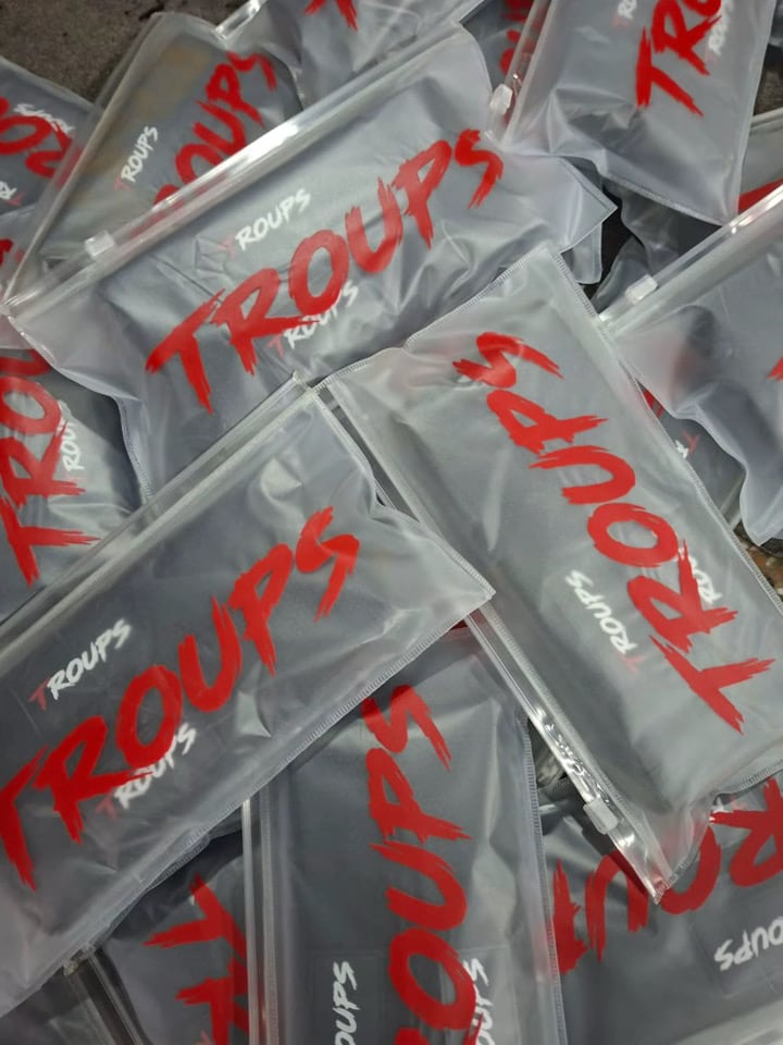 Bolsa con cierre y el logo Troups en rojo, el packaging del primer lote